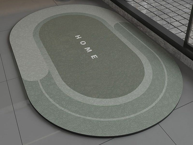 Green oval bathroom non slip rug with 'HOME' text on a bathroom floor
