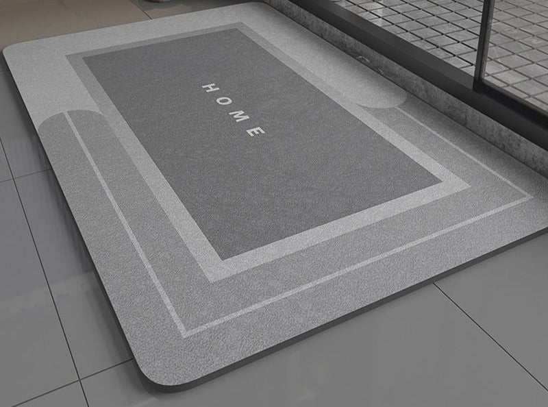 Gray bath mat with 'HOME' text on a bathroom floor