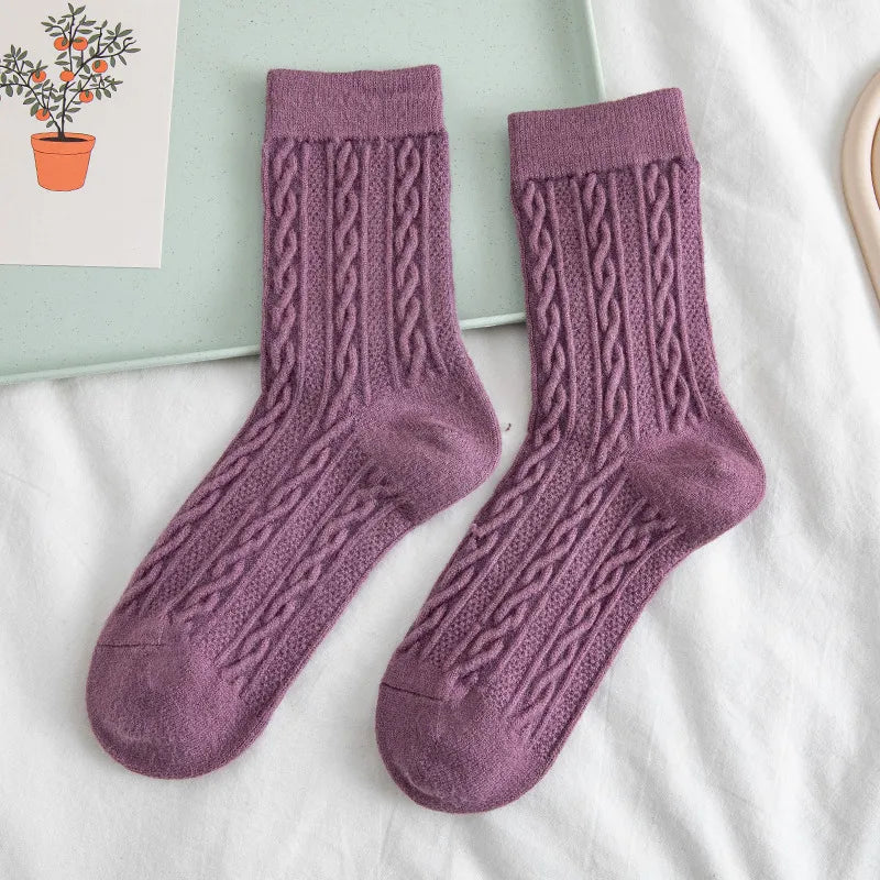A pair of purple floral wool socks displayed against a neutral background.