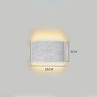 Minimalist aluminium LED wall light mounted on wall, emitting warm up and down lighting in silver finish.