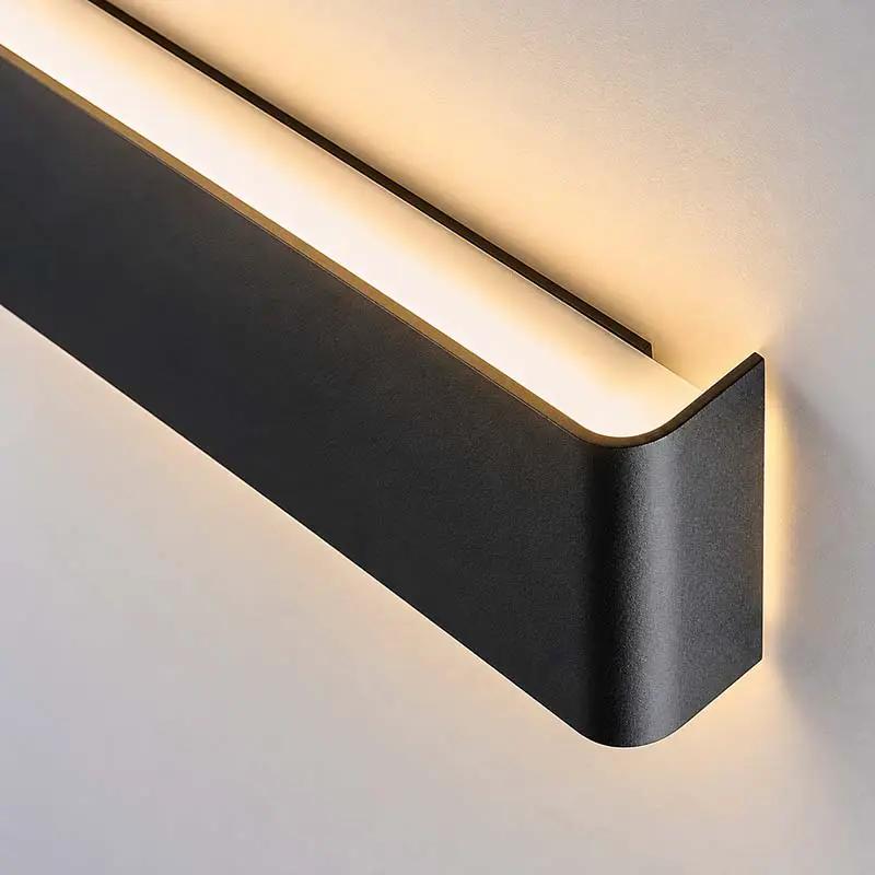 Minimalist LED Wall Light black up-and-down wall lamp mounted on a bedroom wall, casting warm light up and down.