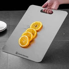 Gray cutting board with sliced oranges and a hand holding it, branded 'Nordic Essentials'.