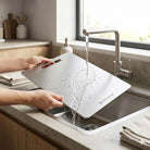 Premium Stainless Steel Chopping Board Nordic Essentials in use under a kitchen tap; double-sided, knife-safe surface.