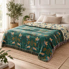 100% Cotton Reversible Throw Blanket used on a bed in a bedroom, teal with bird pattern and fringed edges