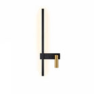 SVEA Swivel LED Wall Light black with brass accent, mounted on a bedroom wall for reading.