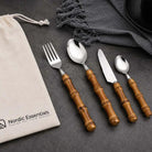 24-Piece Bamboo Handle Cutlery Set Stainless Steel Flatware: 4 bamboo-handle utensils on a dark surface with Nordic Essentials bag.