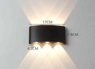 Modern Outdoor LED Wall Lamp, black metal mounted on wall, emits upward and downward glow for garden or living room.