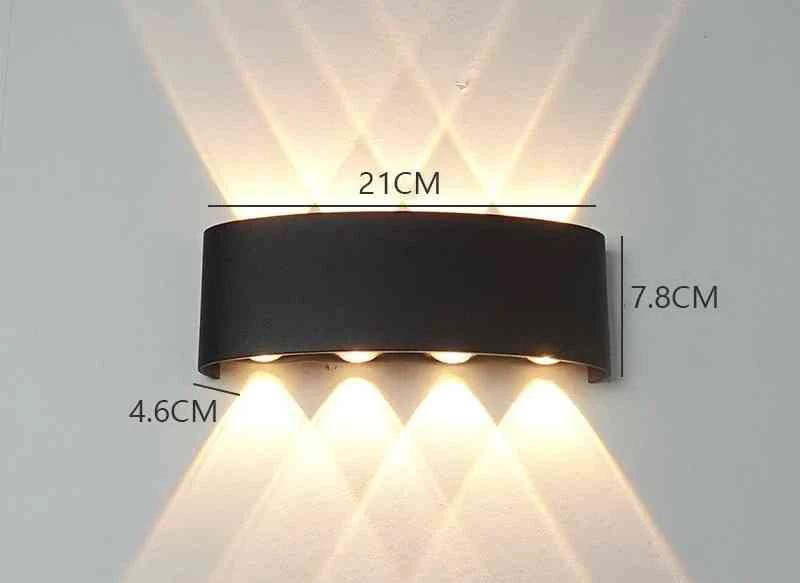 Modern Outdoor LED Wall Lamp, black metal fixture, wall-mounted, emitting upward and downward light on a white wall.