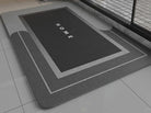 Black bath mat with 'HOME' text on a bathroom floor