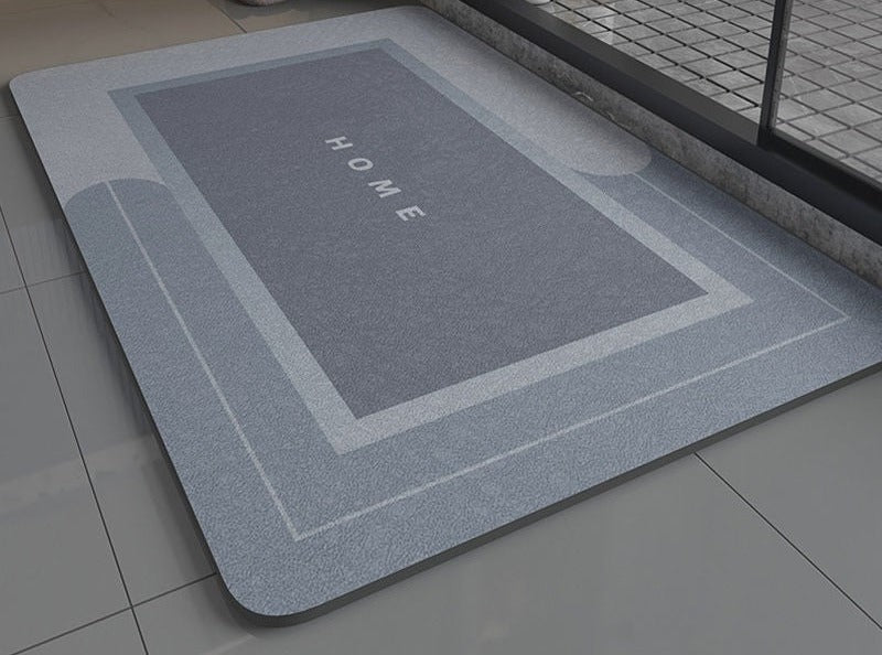 Blue gray non slip bath mat with 'HOME' text on a bathroom floor