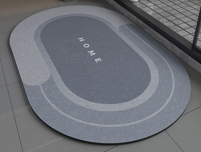 Blue gray non slip bath mat with 'HOME' text on a bathroom floor