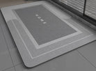 Gray bath mat with 'HOME' text on a bathroom floor